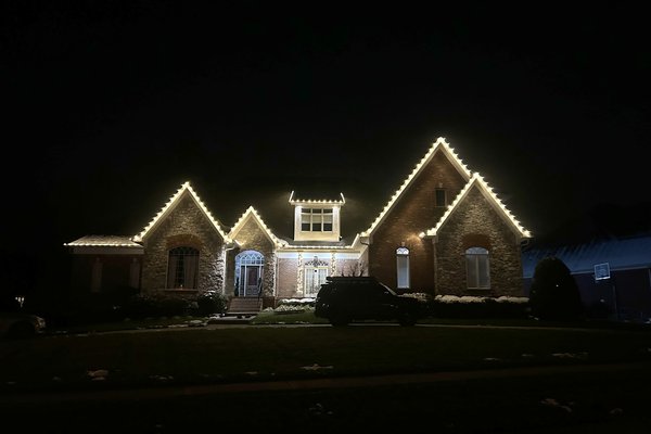 Warm white Christmas lights along a three-gable roofline in Middletown, Kentucky